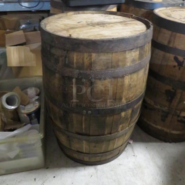 Four Roses whiskey barrel, aged wood with metal bands, used condition, branded top with visible distillery markings.
