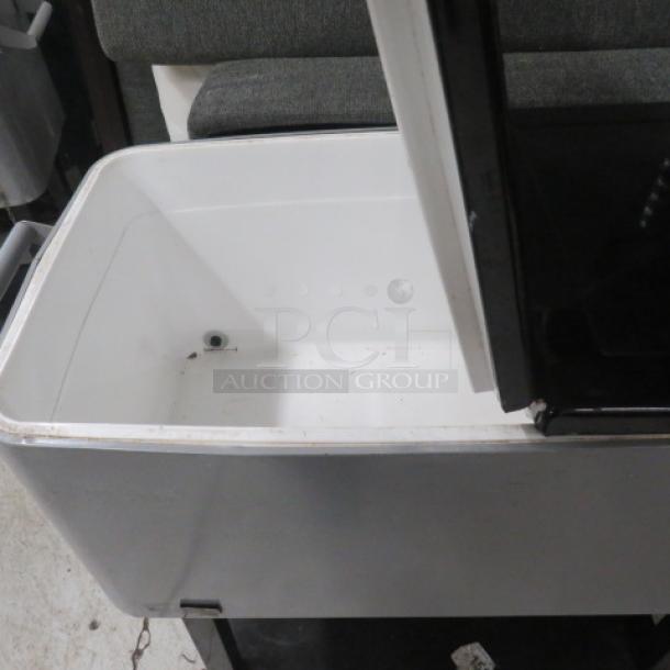 Portable beverage/ice cooler with flip lid, undershelf, and bottle opener on casters. Excellent condition.