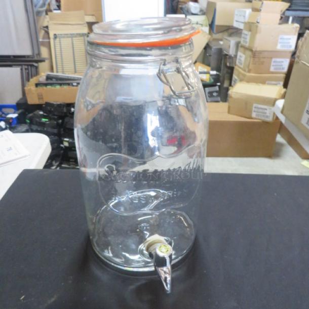One Savannah Co. glass beverage dispenser with spigot and lid, embossed logo. Ideal for serving drinks, good condition.