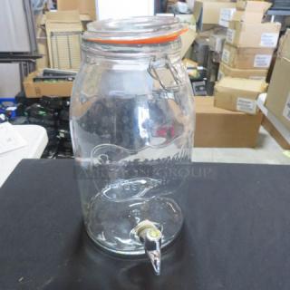 One Savannah Co. glass beverage dispenser with spigot and lid, embossed logo. Ideal for serving drinks, good condition.