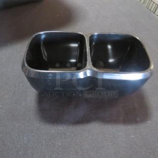 One Lot of 32 black melamine dual condiment servers in a bussing tub, durable and sleek design, ideal for restaurants.