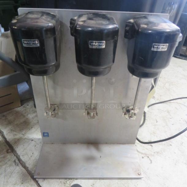 Waring Triple Head Commercial Drink Mixer, Model 32DM15, in used condition. Features three mixing heads on a metal base.