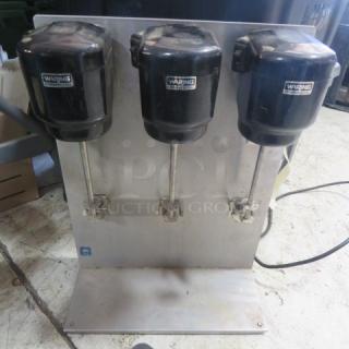 Waring Triple Head Commercial Drink Mixer, Model 32DM15, in used condition. Features three mixing heads on a metal base.