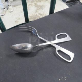 Stainless steel buffet tong, scissor-style, with spoon and fork ends, appears lightly used.