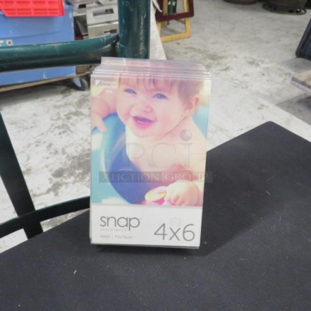 One lot of 12 table marker holders, Snap brand, 4x6 inch, clear acrylic, new condition, suitable for menus or photos.