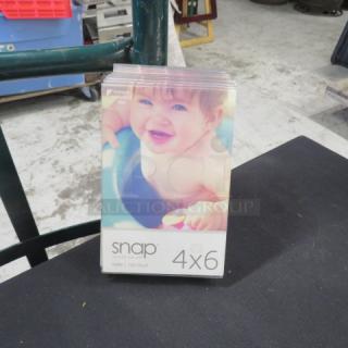 One lot of 12 table marker holders, Snap brand, 4x6 inch, clear acrylic, new condition, suitable for menus or photos.