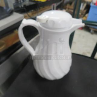 White swirl beverage dispenser, model 2XBID, with a screw-on lid and handle. Good condition, ideal for serving drinks.