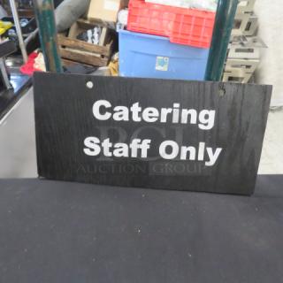 "Catering Staff Only" sign, black with white text, slight wear.