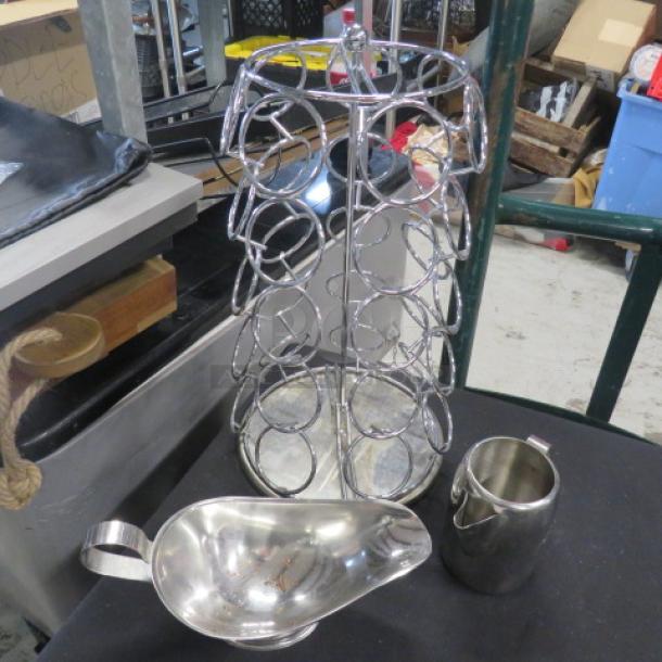 Lot of assorted metal kitchenware, including a large circular wine rack, a gravy boat, and a metal pitcher. Items show light wear.