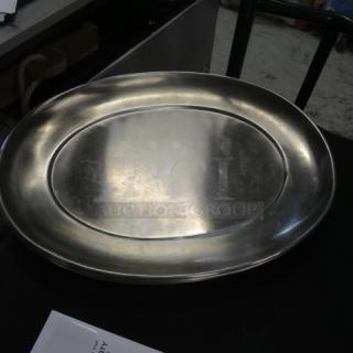 20.5x16 stainless steel platter with oval design, pre-owned condition. Some surface scratches, reflective shine.