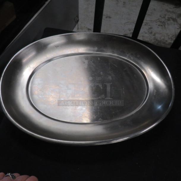 17.5x13 stainless steel platter, gently used, oval shape. Minor surface wear, no visible markings or labels. Ideal for serving.