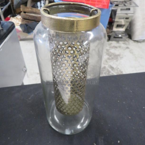 10-inch tall glass candle holder with brass top and perforated metal inner sleeve, model 7XBID, in good condition.