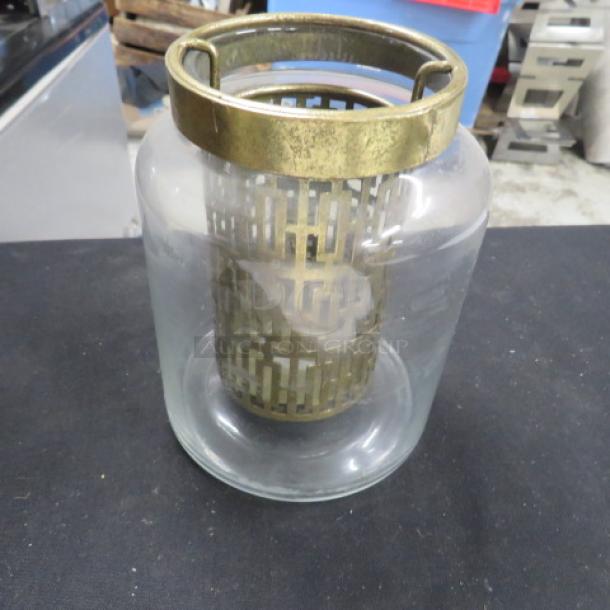 6-inch tall candle holder with bronze metal top and lattice design inside a clear glass cylinder. Good condition.