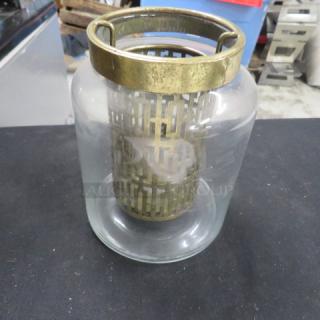 6-inch tall candle holder with bronze metal top and lattice design inside a clear glass cylinder. Good condition.