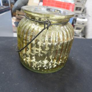 Gold candle holder with ribbed glass design, metal handle, and vintage finish. Suitable for decor or illumination.