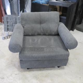 Comfortable gray chair, 43x33x32 inches, features plush cushions and rounded armrests. Appears in good condition.