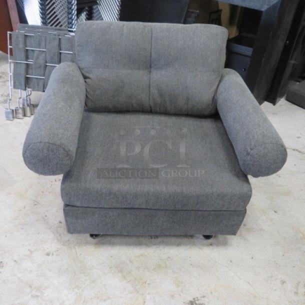 Gray armchair with cushioned back and armrests. Dimensions: 43x33x32 inches. Upholstered in smooth fabric, appears in good condition.