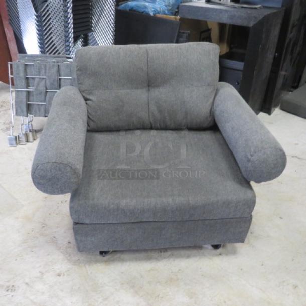 Comfortable gray chair, dimensions 43x33x32, featuring plush upholstery and rounded armrests, in good condition.