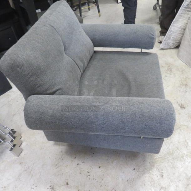 Comfortable gray chair, 43x33x32 inches, plush fabric, sturdy frame, slightly worn condition, ideal for living spaces.