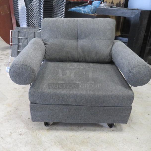Comfortable gray chair, 43x33x32 inches, upholstered, cylindrical armrests, on wheels, good condition.