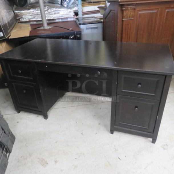 Black wooden desk with five drawers, dimensions 65.5x29.5x29.5 inches. Shows minor wear, sturdy build, minimalist design.