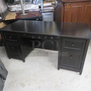 Black wooden desk with five drawers, 65.5x29.5x29.5 inches, in good condition. Smooth finish, ideal for office use.