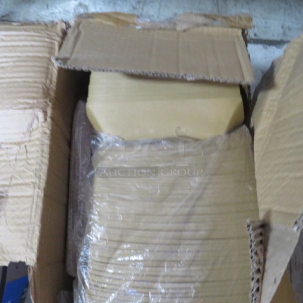 Cardboard box containing a lot of paper boats wrapped in plastic. Box is partially open, showing stacked paper inside.