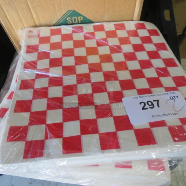 12x12 case of red and white checkered deli papers, sealed in plastic, by SQP. Includes auction tag with number 297.