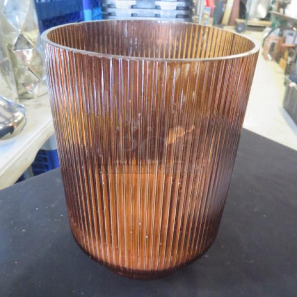 Ribbed brown glass vase, cylindrical shape, part of a collection of 13 vases, displayed on black surface.