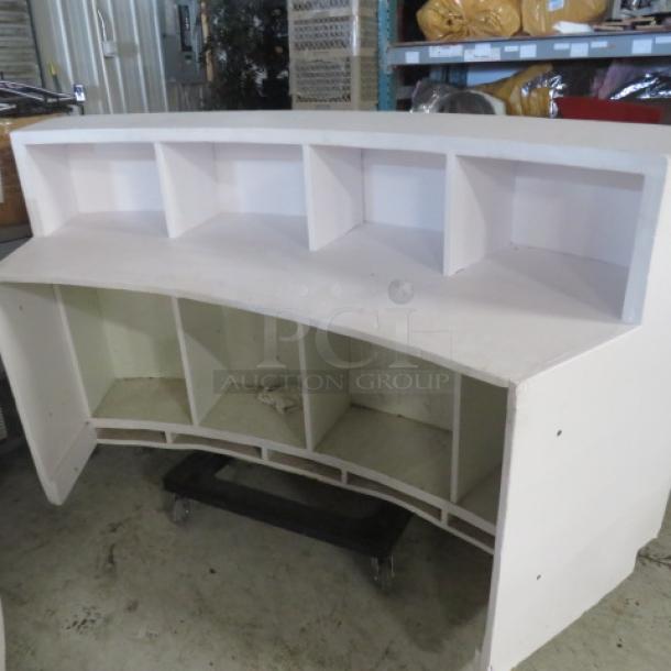 Curved wooden portable bar/hostess stand with under storage, measuring 77x30x42 inches. Good condition, white finish.