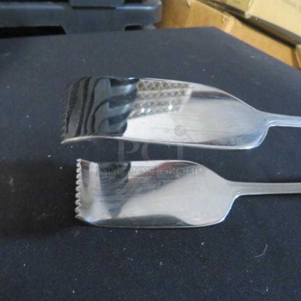 Stainless steel buffet tong, polished finish, serrated edges, excellent condition, model 4XBID. Ideal for serving.