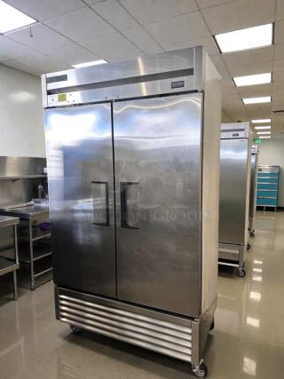 Commercial grade stainless steel two-door reach-in refrigerator in immaculate condition, bottom-mount, fully tested.