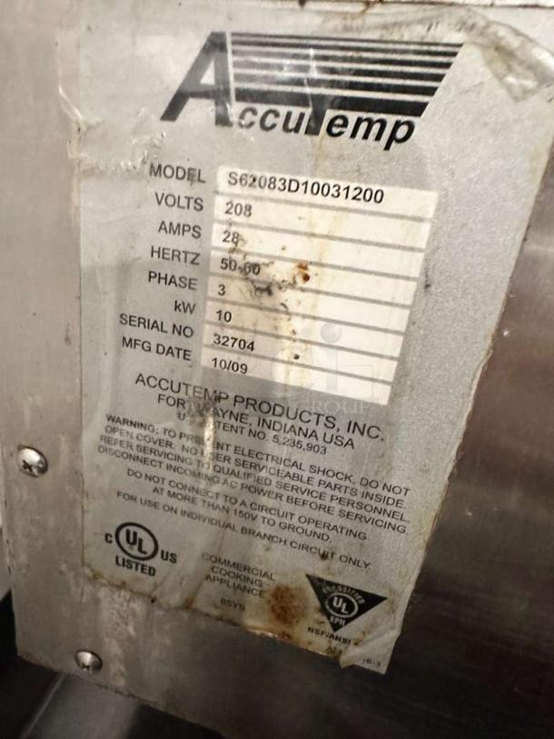 AccuTemp Steam 'N' Hold steamer tag showing model S62083D10031200, voltage 208, amps 28, hertz 50/60, and serial 32704.