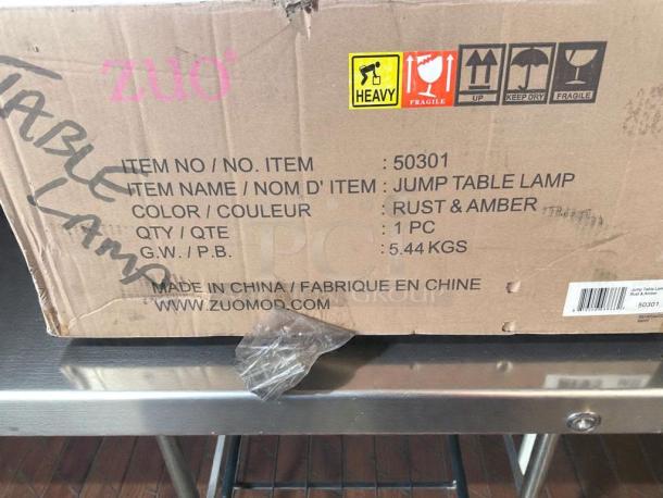 Box of Zuomor Jump Table Lamp Set, new, model 50301, Rust & Amber color, 3-light, 5.44 kg, commercial grade.