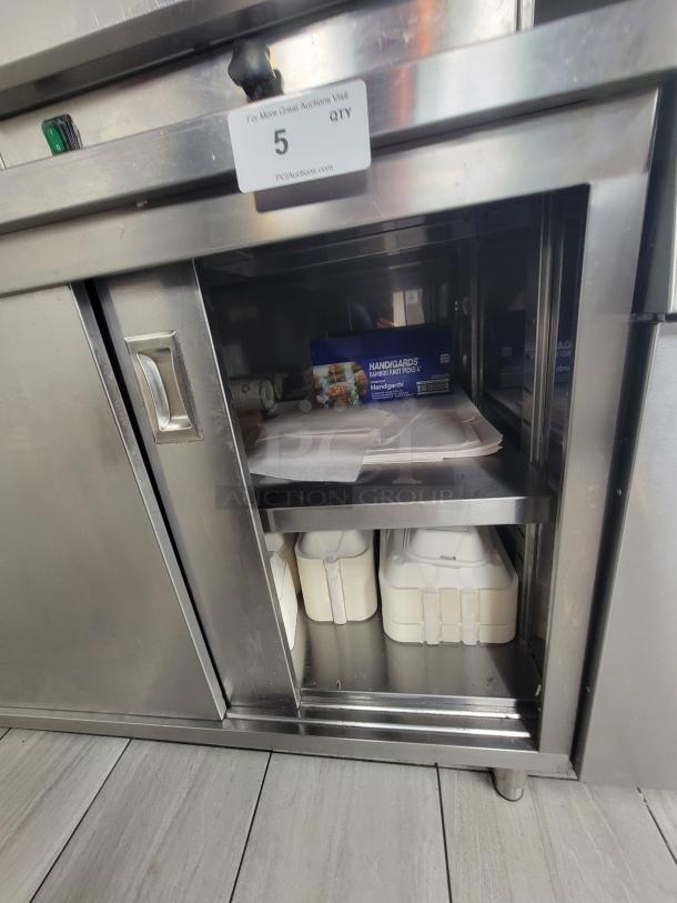 Commercial stainless steel work table by KCS, model 415, with sliding doors and adjustable shelving. NSF certified.