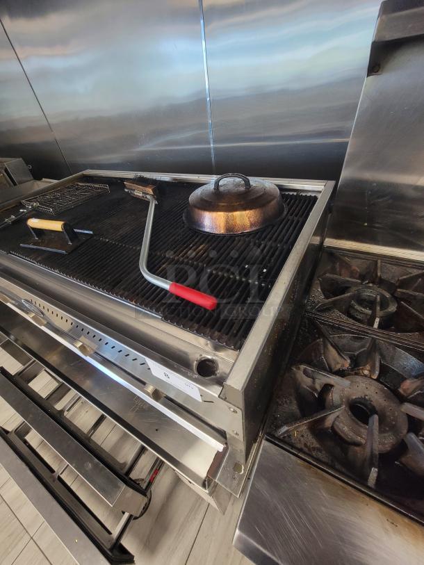 Royal 4' Commercial NG Charbroiler, model RRB-48, with 4 burners, cast iron grates, accessories included, used, well-maintained.