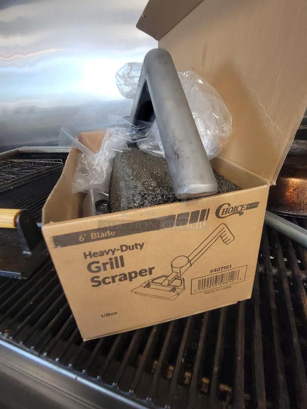 Box of heavy-duty grill scraper and accessories on Royal 4' NG Charbroiler, used condition, showing metal grill surface.