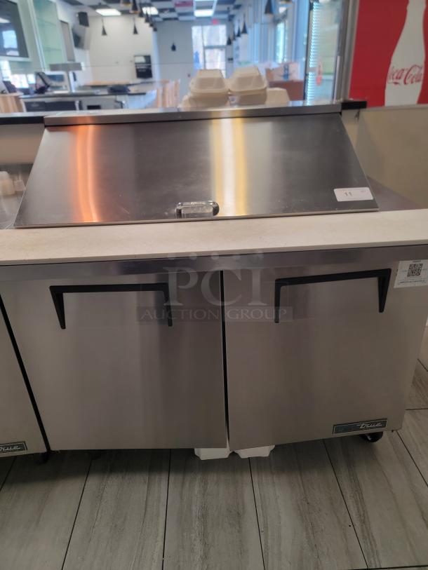 True TSSU-48-18M-B-HC sandwich prep table, 48" stainless steel, dual doors, 18-pan capacity, on casters, eco-friendly refrigerant.