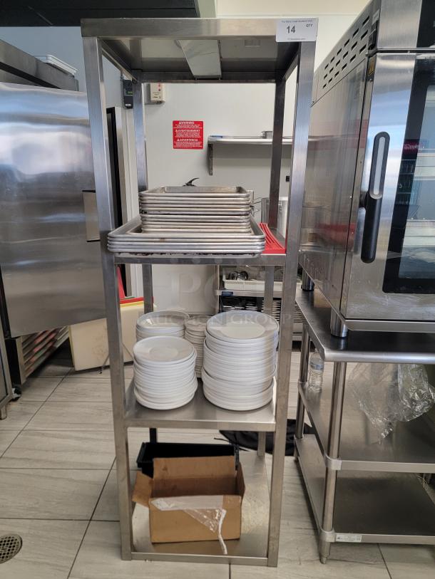 Heavy-duty stainless steel kitchen shelving unit with sheet pans, ceramic plates, bowls, and multi-tier rack, perfect for commercial use.