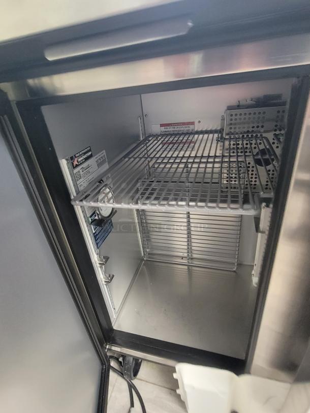 True TUC-36-HC undercounter refrigerator, stainless steel, like new, with R290 refrigerant, casters, and internal shelving.