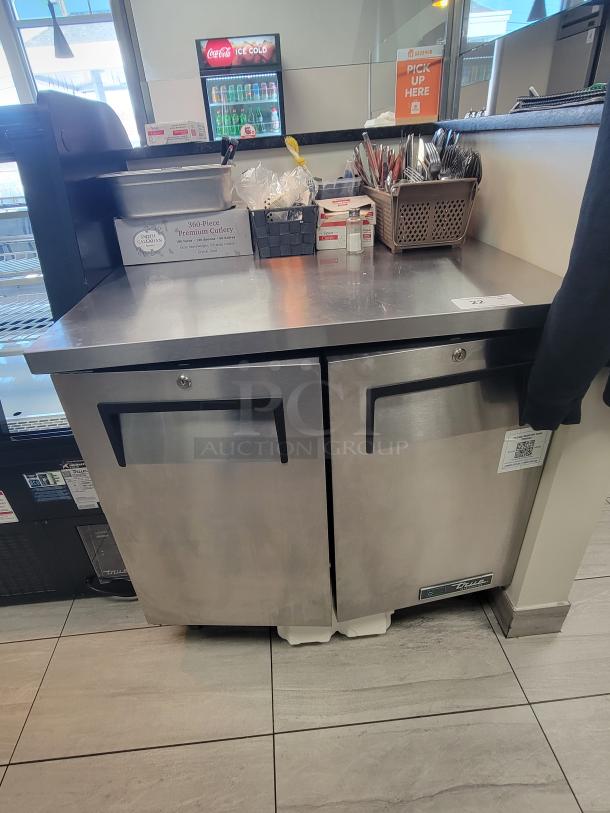 Stainless steel True TUC-36-HC under-counter fridge, dual doors, casters, excellent condition, ideal for commercial use.