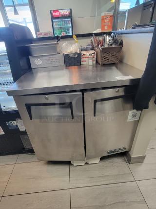 Stainless steel True TUC-36-HC under-counter fridge, dual doors, casters, excellent condition, ideal for commercial use.