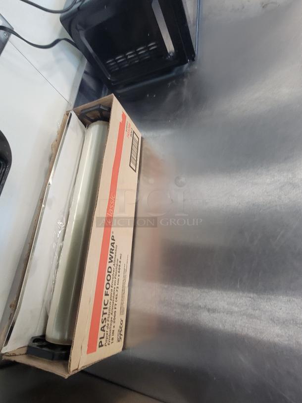 KCS Stainless Steel Work Table, Model 415, with microwave and plastic wrap. Smooth finish, key kitchen upgrade.