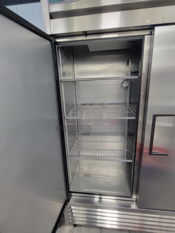 True T-49-HC double door refrigerator in pristine condition with stainless steel exterior and spacious shelving. Energy-efficient.