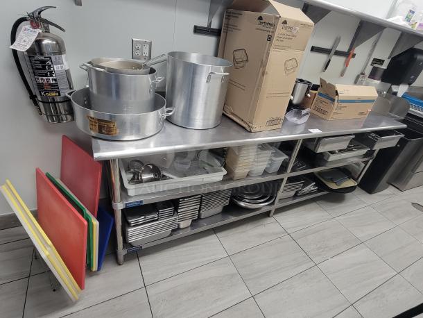 9' Sapphire Professional stainless steel workstation, model 108, with cutting boards, pots, utensils, and storage shelves.