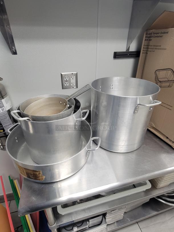 Professional 9' Stainless Workstation by Sapphire, model 108, with pots and kitchen tools on top. Ideal for commercial use.