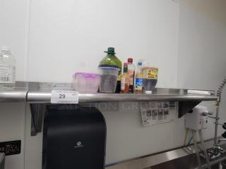 Stainless steel wall shelf KCS WSSL-24X with kitchen essentials: olive oil, sauces, honey, containers. NSF-certified.
