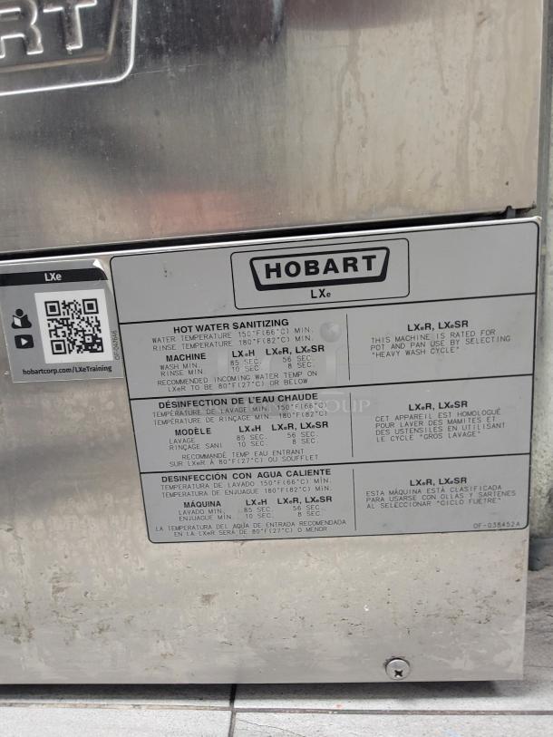 Hobart LXe commercial dishwasher, stainless steel. Features hot water sanitizing. Visible model label detailing sanitizing specs.