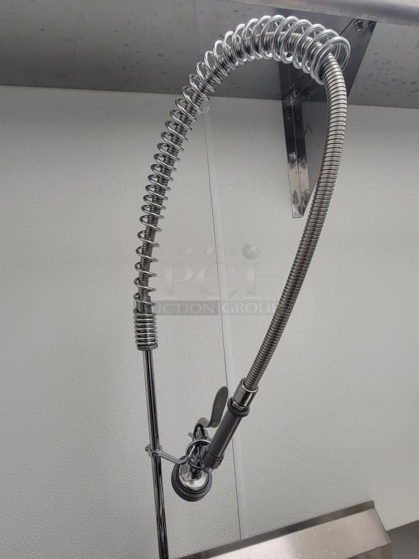 Stainless steel pre-rinse faucet with spring design from KCS, part of a commercial kitchen dish station. Mint condition.