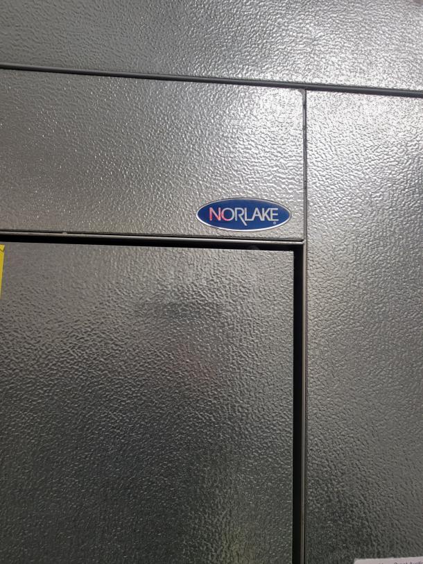 Norlake walk-in cooler door with brand logo, textured gray surface, in excellent condition.